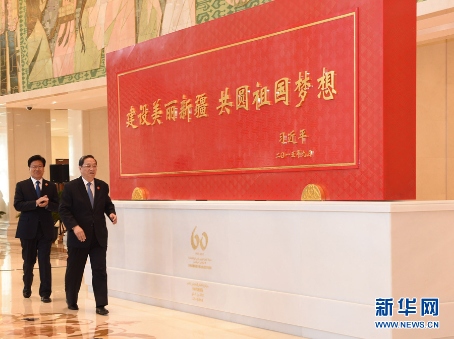 這是俞正聲和中共中央政治局委員、新疆維吾爾自治區黨委書記張春賢一同為習近平總書記題詞賀匾揭幕。新華社記者 高潔 攝 